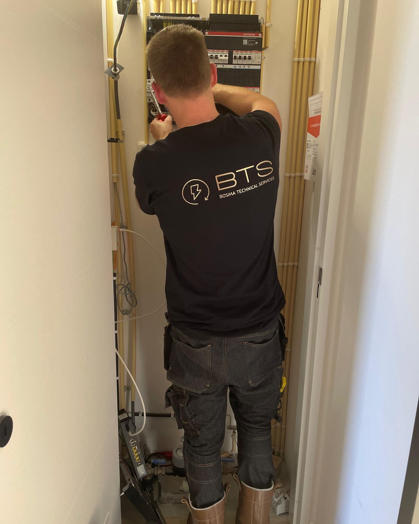 Daniël van BTS bezig met de bedrading in de meterkast